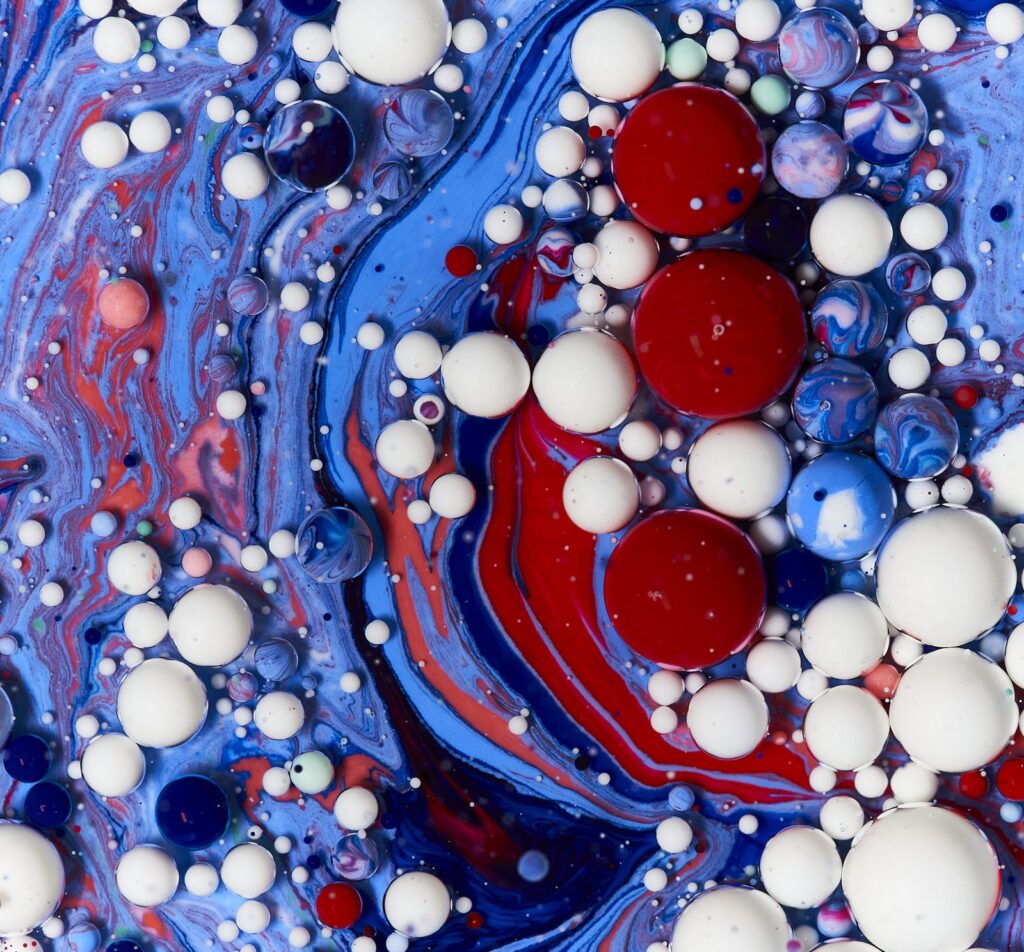 Blue, red, and white bubbles in swirling liquid