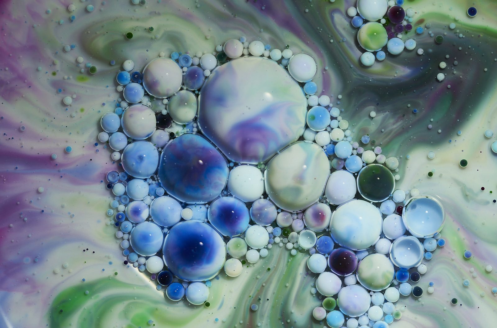 Pale blue bubbles clustered in green and violet swirls