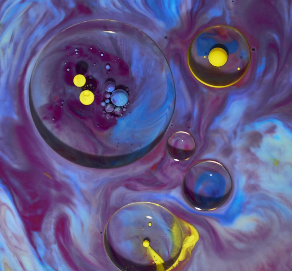 Large bubbles with yellow droplets in magenta and blue swirls