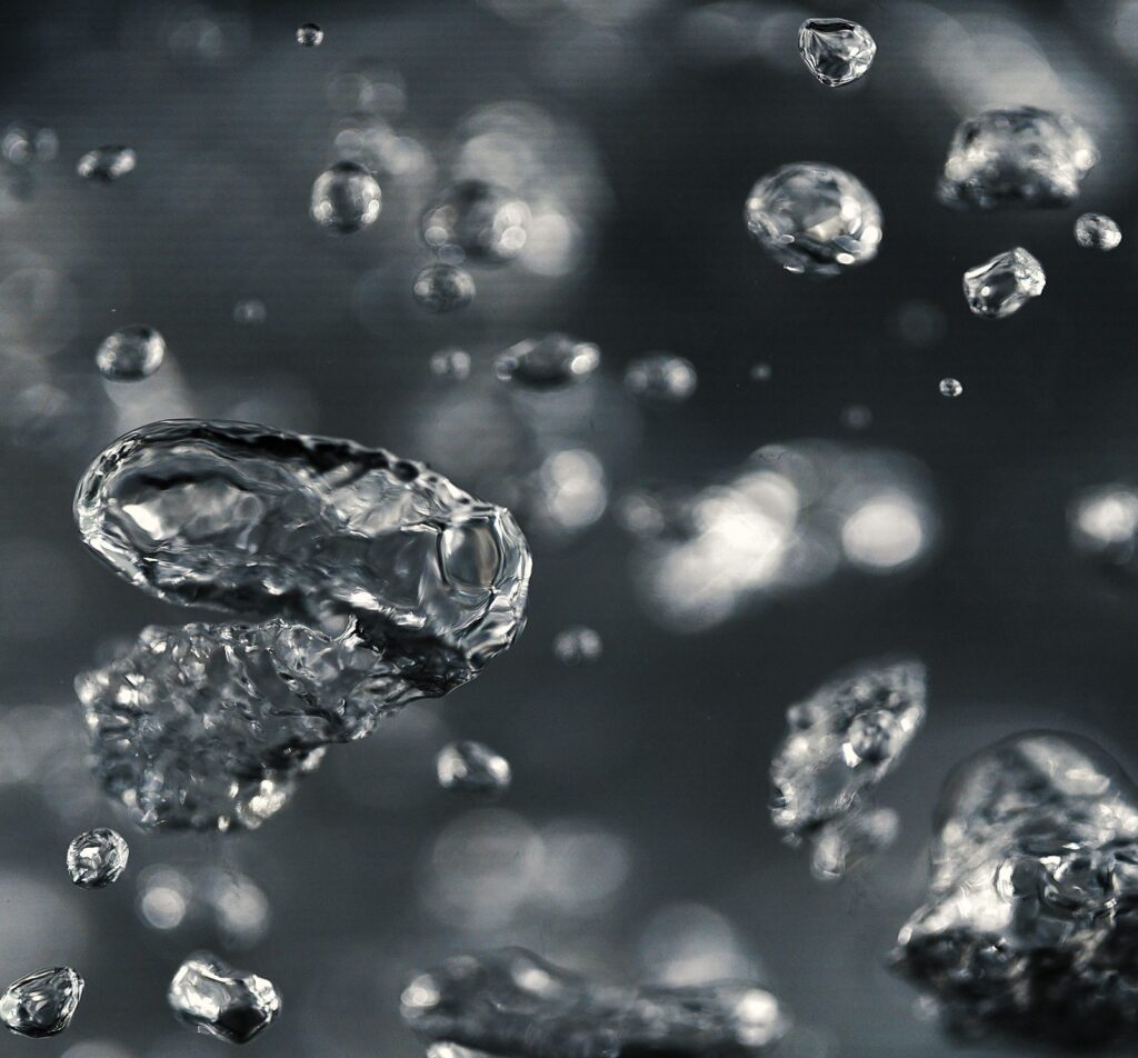 Ice bubbles and crystals floating against a dark background