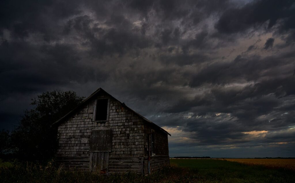 Dark old barn beneath a storm sky