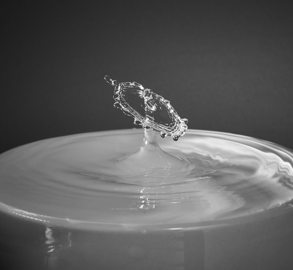A water droplet rising from a ripple