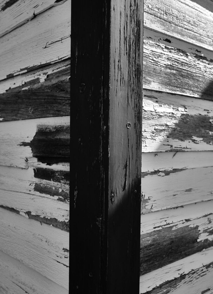 Peeling white paint on wooden boards