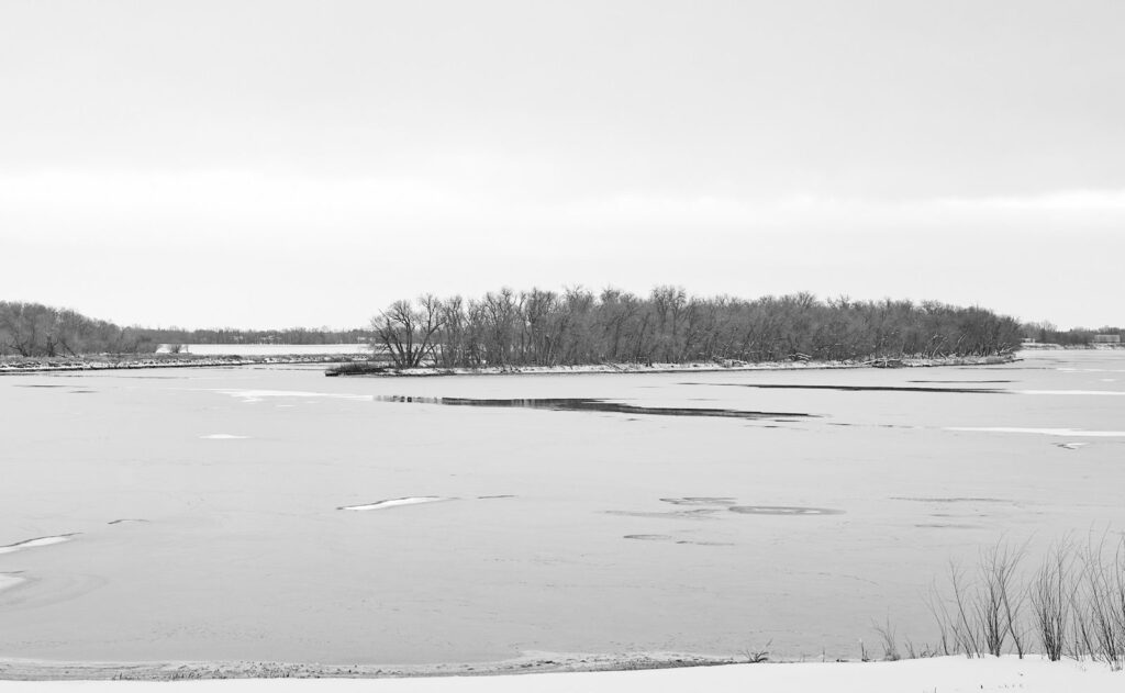 Frozen shoreline and ice floes in late autumn, in black and white