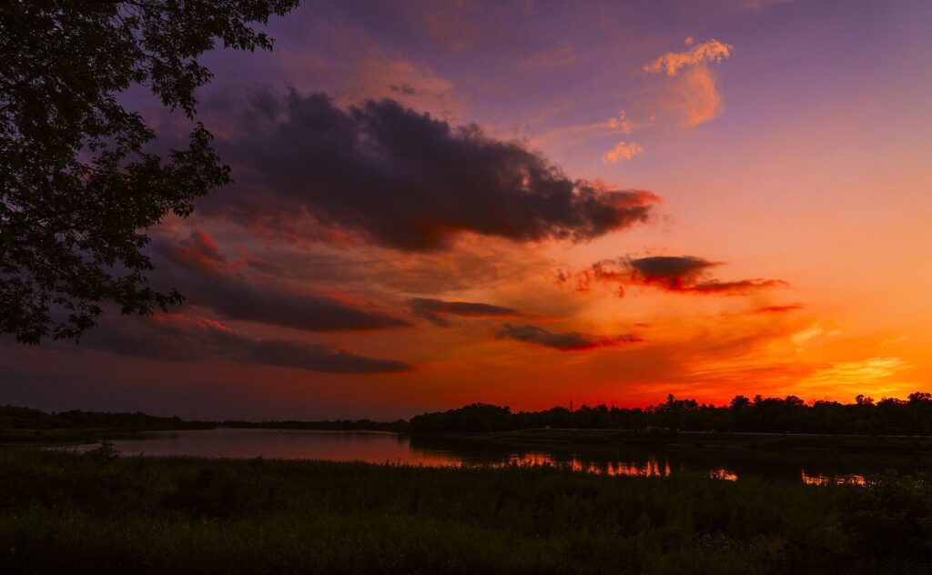 Purple and orange sunset clouds over a river bend