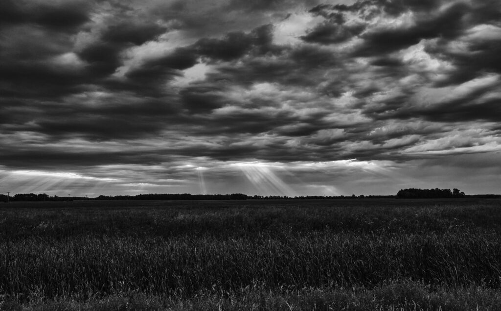 Sunbeams through rippled clouds over a field