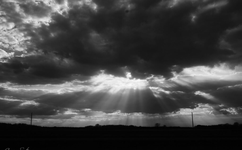 Sunbeams fanning out beneath dark storm clouds