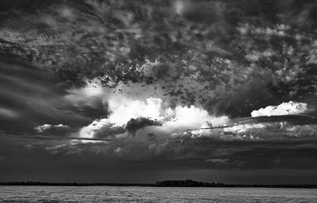 Dark clouds opening over a flat horizon