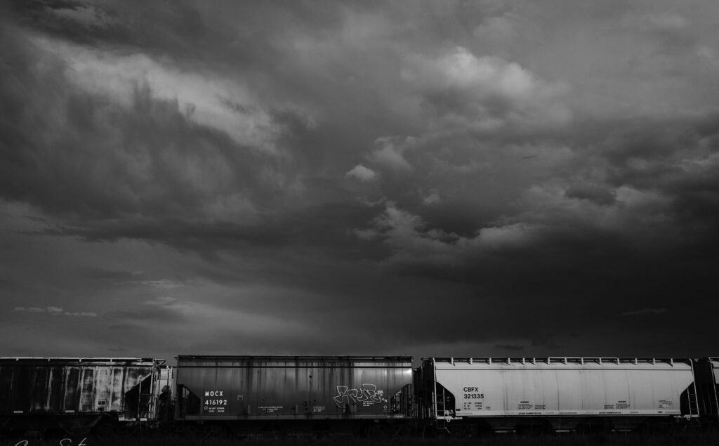 A storm front rolling in behind a freight train
