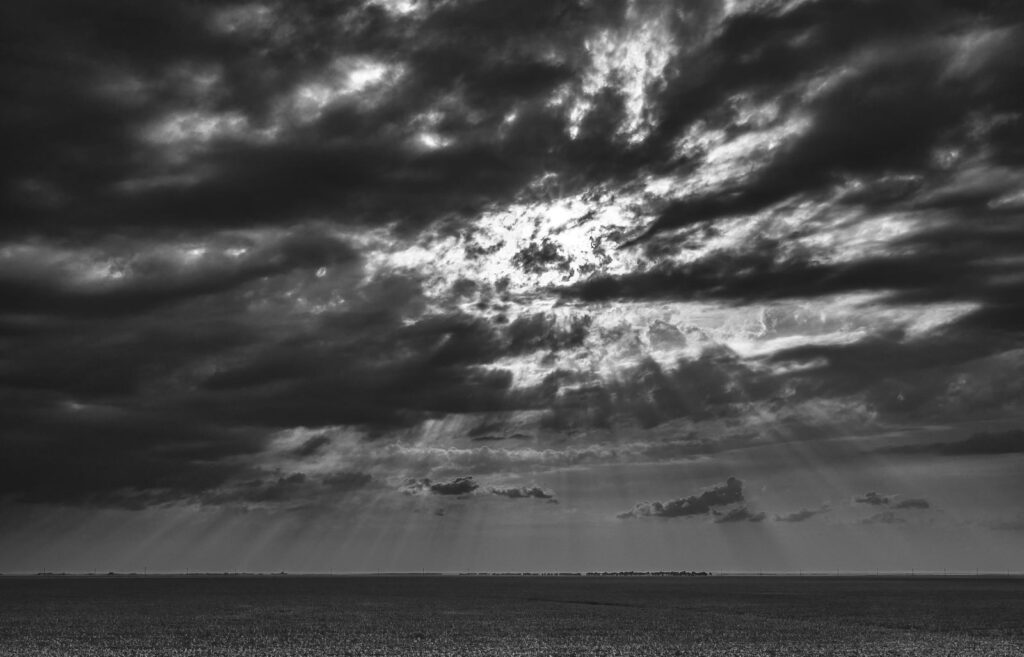 Light breaking through cracked clouds over a lake