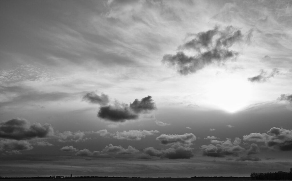 Evening light through scattered clouds over open land