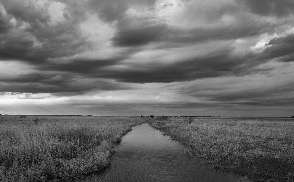Heavy clouds over a drainage ditch
