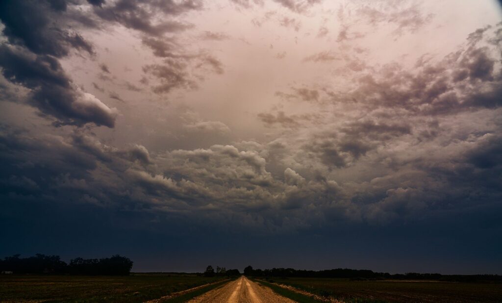 Textured storm clouds above a distant road
