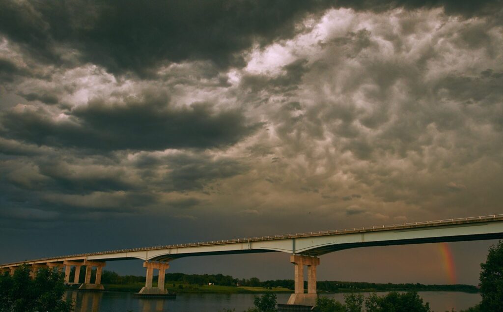 Storm clouds over a long highway bridge