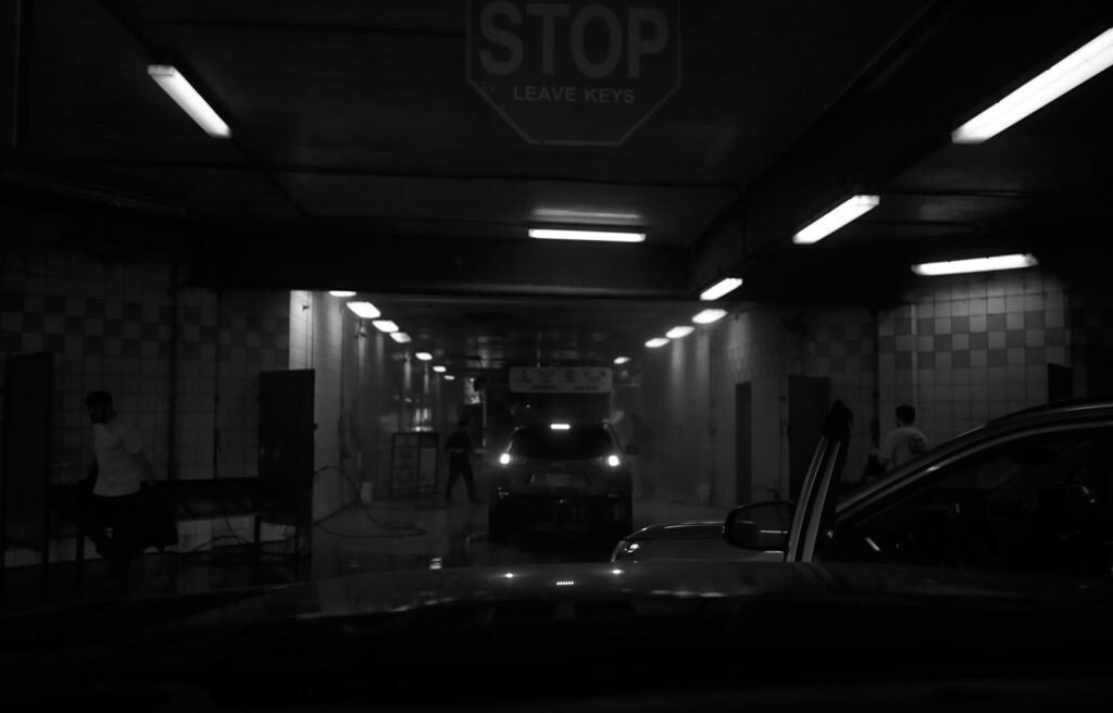 Dim parking garage tunnel with a stop sign and glowing ceiling lights