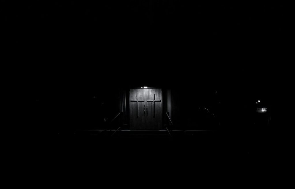 Door lit by a single light on a dark building at night
