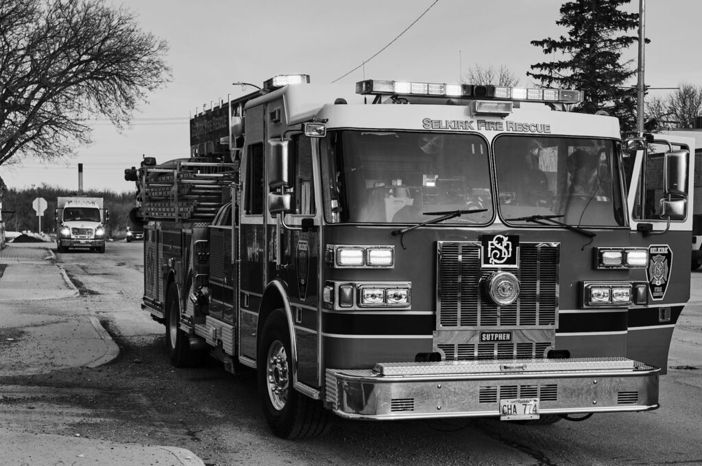 Fire truck with its lights on parked at the side of a street