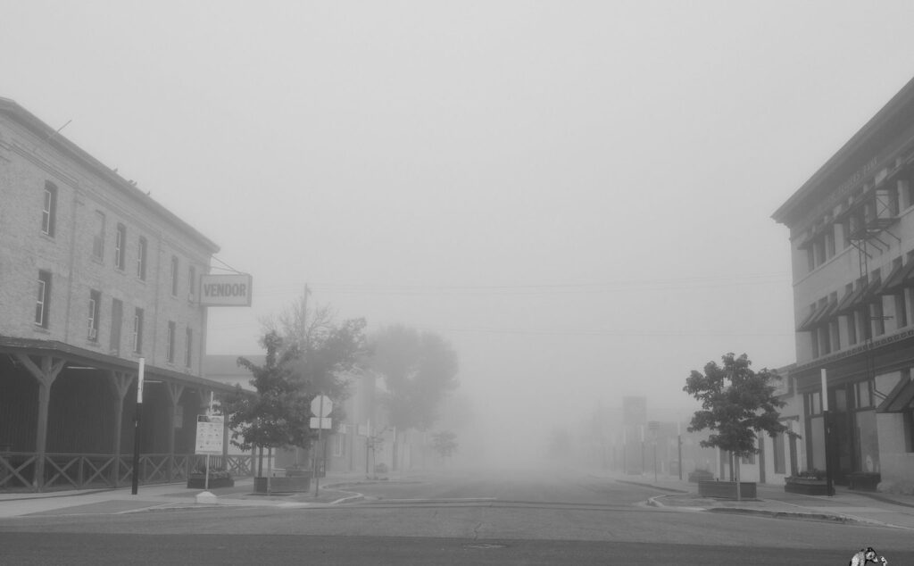 Foggy morning street lined with old brick buildings
