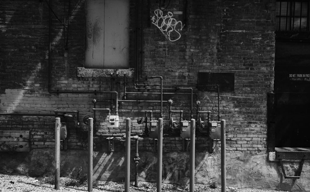 Row of gas meters against a worn brick wall