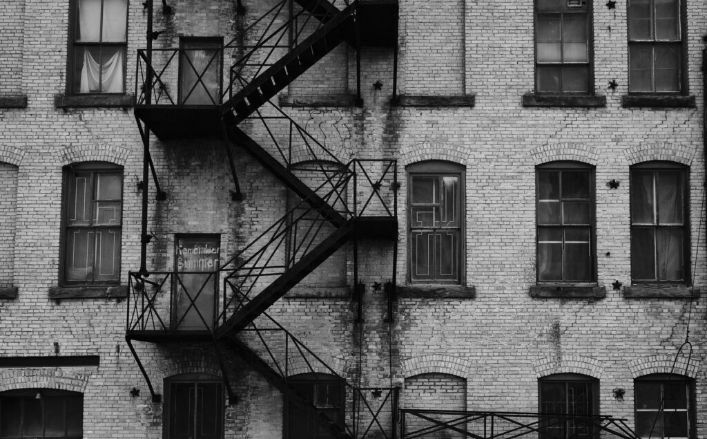 Brick building with iron fire escapes and tall windows
