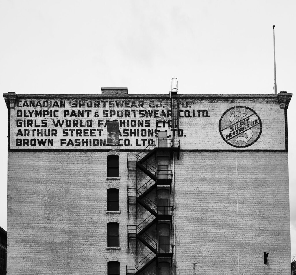 Painted wall sign on the side of a tall brick building