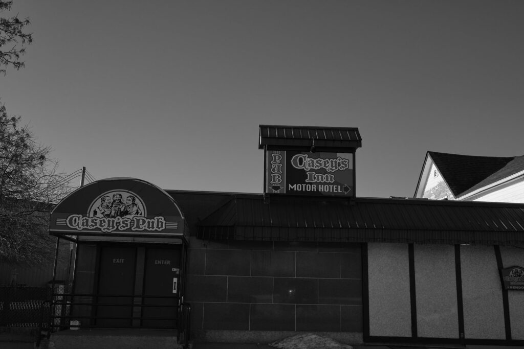 Pub and motel sign at dusk above a long low roofline