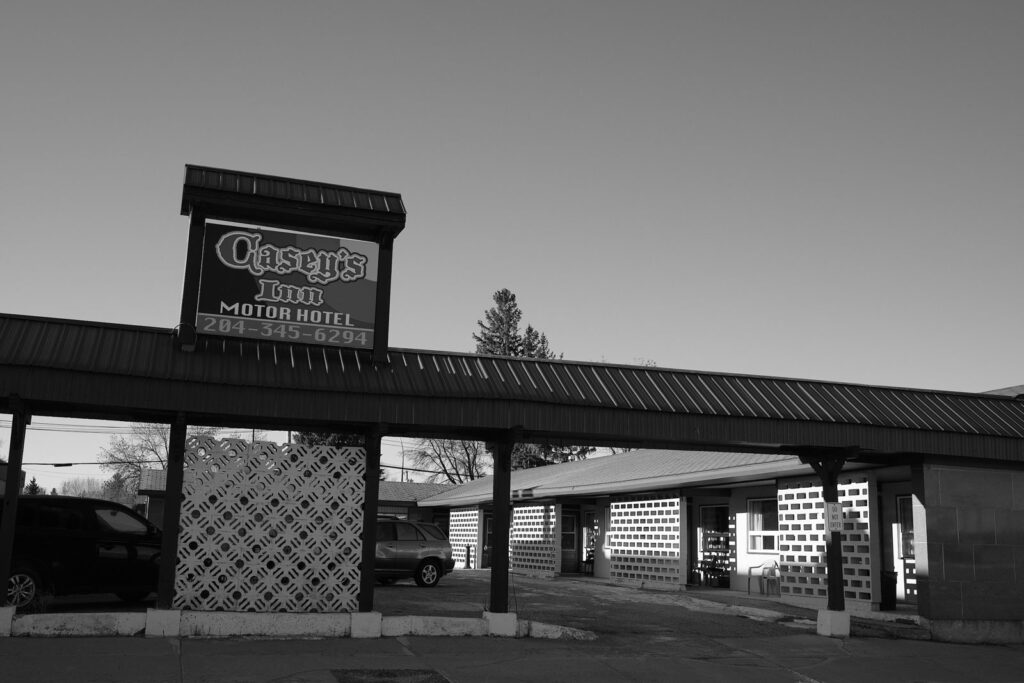 Motor hotel sign above a covered walkway with patterned block walls
