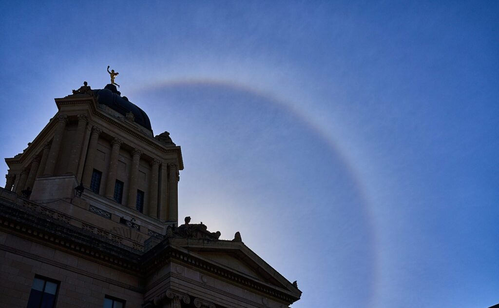 Circular halo around the sun above a historic stone building