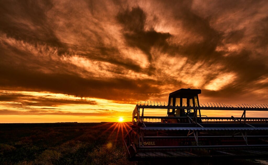 Combine silhouetted against a fiery sunset sky