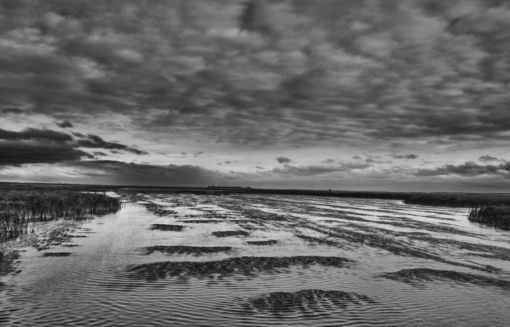 Rippled shallow water and sand flats under heavy clouds