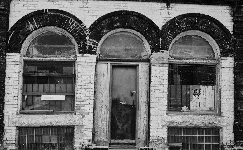 Abandoned arched storefront with a painted brick facade
